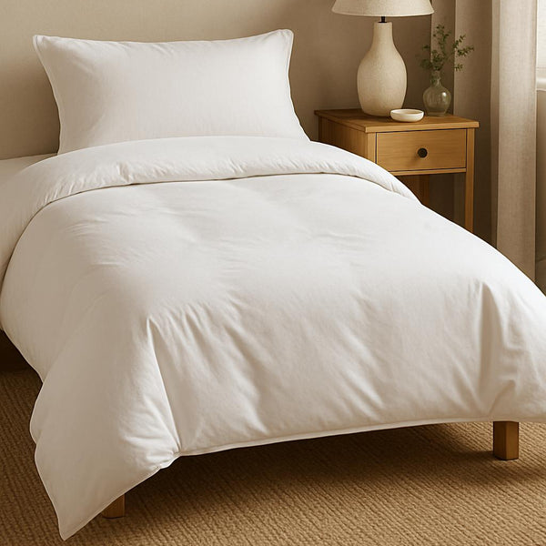 Neatly made bed with white bedding in a bedroom setting.